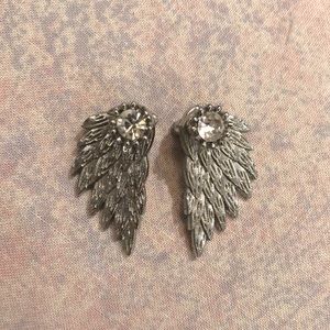 Silver tone angel wing earrings with rhinestone studs.